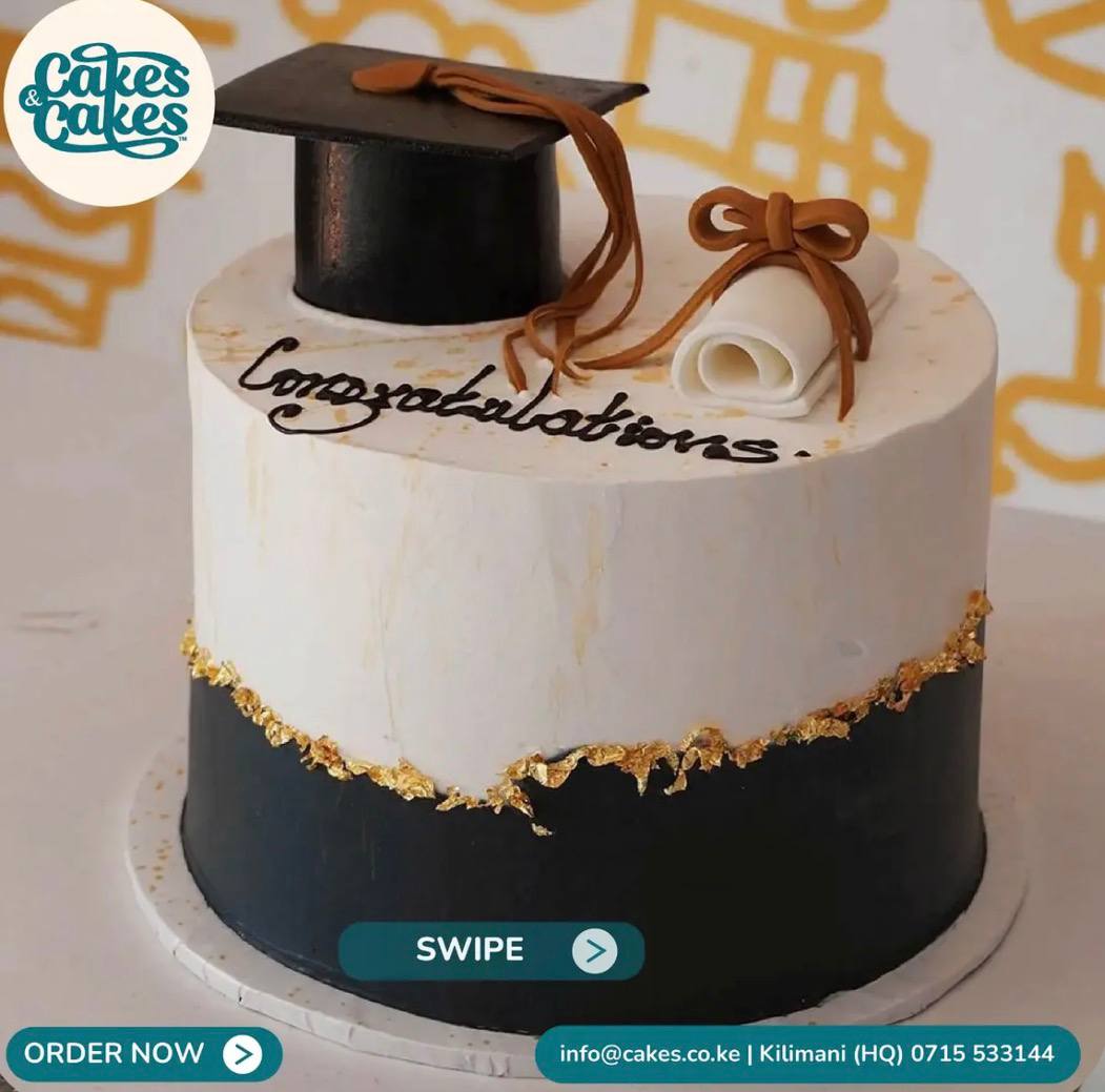 Graduation cake by Cakes & Cakes: white and black two-tone buttercream with a torn gold-leaf seam, a fondant graduation cap and ribboned scroll on top, and "Congratulations" hand-piped in dark chocolate.